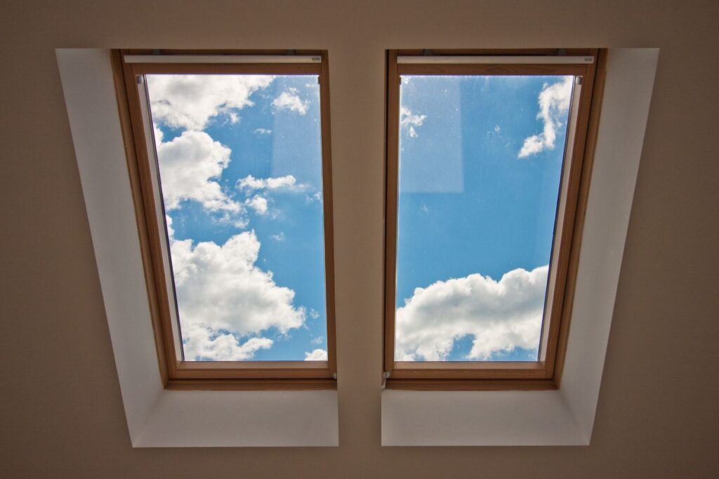Skylights. View from the window. View of the sky from the window. Window on the roof. Sunlight through the attic window. Light in the house